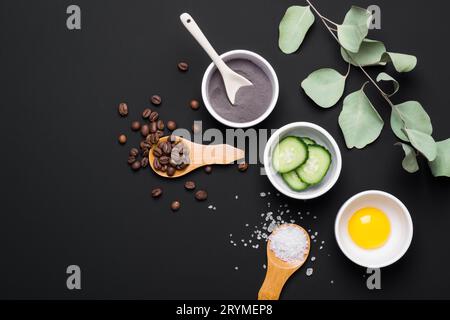 Ingredienti naturali per creare cosmetici fai da te per la cura della pelle. Set di vari ingredienti organici su sfondo nero del tavolo Foto Stock