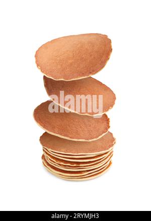 Molti gustosi pancake freschi che cadono su sfondo bianco Foto Stock