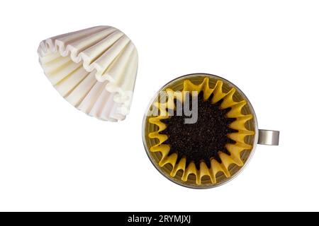 Vista dall'alto dei nuovi filtri di carta usa e getta a cestello e dei chicchi di caffè tostati macinati in filtro di carta per caffè in meta Foto Stock