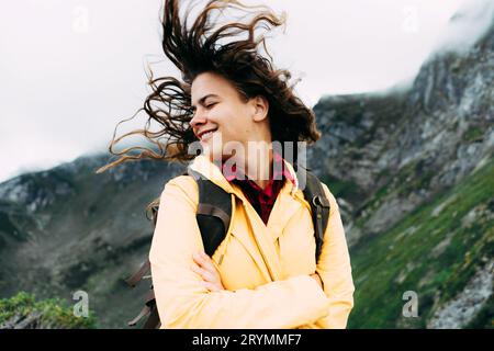 Una giovane donna rilassata si torce la testa e i capelli lunghi soffia nel vento Foto Stock