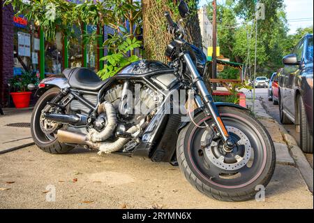 NEW ORLEANS, LOS ANGELES, USA - 28 SETTEMBRE 2023: Moto Harley-Davidson nera brillante, che mostra un po' di usura parcheggiata di fronte al marciapiede Foto Stock
