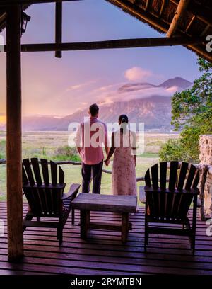 Una coppia di uomini e donne di mezza età davanti al loro alloggio durante le vacanze nella South Africa Garden Route Foto Stock