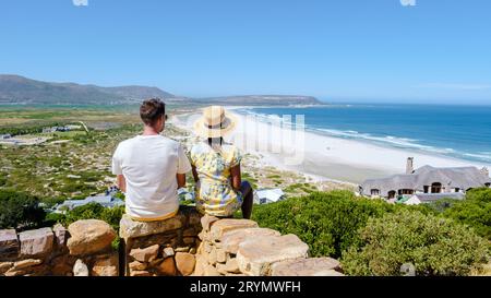 Splendida spiaggia di sabbia bianca di Noordhoek lungo Chapman's Peak Drive città del Capo, Sudafrica. Noordhoek Beach città del Capo. Un uomo e una donna al limite di un becco Foto Stock