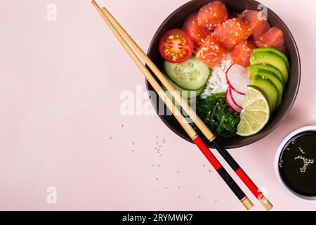 Insalata di pollo al salmone hawaiano con riso, verdure e alghe marine su sfondo rosa Foto Stock