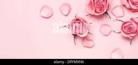 Sfondo di boccioli di rosa e petali con busta al centro e una tazza di tè  con boccioli di rosa e cucchiaio da tè. Piano di giacitura, vista  dall'alto. Festa della mamma