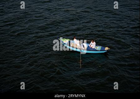 Artigiani locali che si avvicinano con ansia per mostrare ai passeggeri di una piccola nave da crociera i loro beni unici. Foto Stock