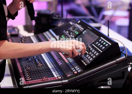 L'operatore della console di miscelazione del suono controlla le impostazioni prima dell'evento live. Messa a fuoco selettiva. Foto Stock