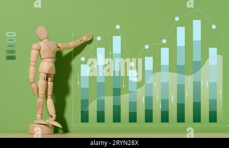 Manichino in legno e grafico con indicatori crescenti su sfondo verde. Analisi degli indicatori finanziari nelle imprese, reddito g Foto Stock