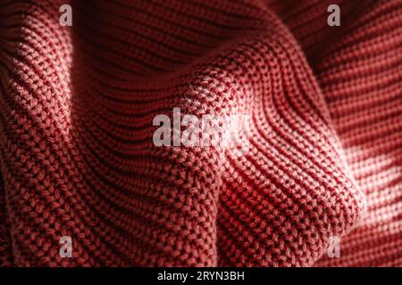 Texture lavorata a maglia di un maglione rosa o di una sciarpa da vicino. Foto Stock