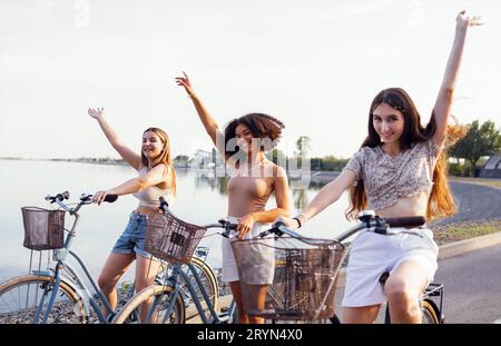 Adolescenti di diverse nazionalità e aspetto in bicicletta percorrono una strada cittadina Foto Stock