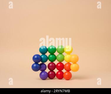 Sfondo astratto con palline di plastica multicolore su sfondo beige, palcoscenico per la dimostrazione di cosmetici e prodotti Foto Stock