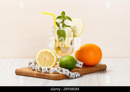 Limonata gassata con fette di fragola, menta con frutta sulle tavole di legno Foto Stock