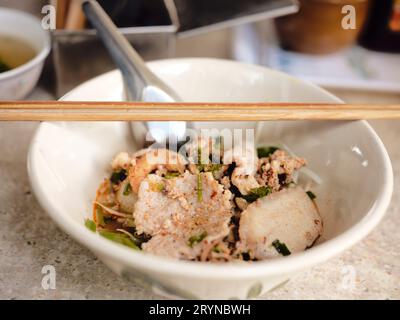 Cibo di strada tailandese. Noodle Tom Yum, spaghetti con maiale e piccante, Closeup Spicy TOM YAM, spaghetti piatti piccanti al gusto di citronella con maiale. Foto Stock