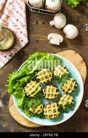 Antipasto natalizio d'autunno. Champignons al forno con purè di patate su un tavolo rustico. Vista dall'alto sfondo piatto. Foto Stock