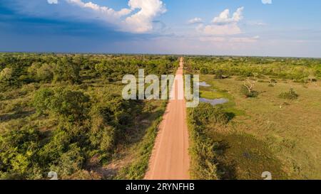 Vista aerea con nuvole e cielo blu all'orizzonte della strada sterrata Transpantaneira che attraversa dritto Foto Stock