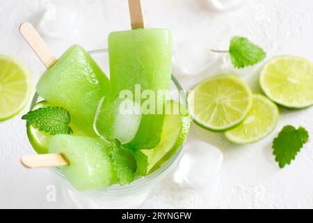 Ghiaccioli sani alla menta di lime con fette di lime fresche e cubetti di ghiaccio Foto Stock