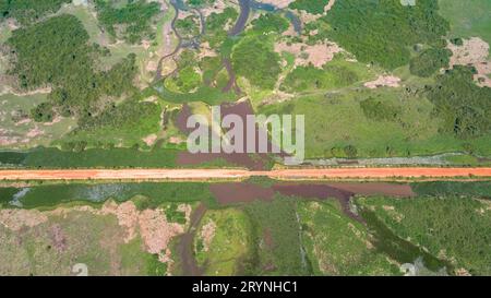 Veduta aerea della strada sterrata di Transpantaneira che attraversa il tipico paesaggio delle paludi Pantanal con lagune, fiumi, prati e foreste, Mato Grosso, Brasile Foto Stock