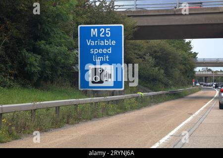 Viaggiando lungo l'autostrada M25 con segnaletica stradale che indica l'applicazione della velocità sulla velocità variabile imposta. Foto Stock