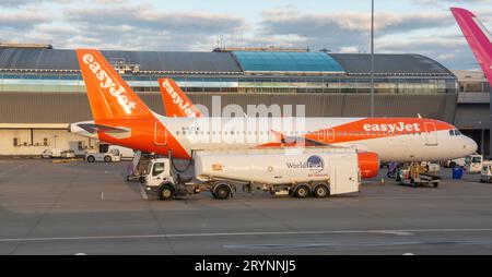 Londra, Regno Unito - 11 maggio 2023: Aereo low cost EasyJet con autocarro World Fuel Services accanto ad esso presso l'aereo London Luton Foto Stock