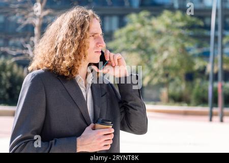 uomo d'affari che parla all'aperto con il cellulare Foto Stock