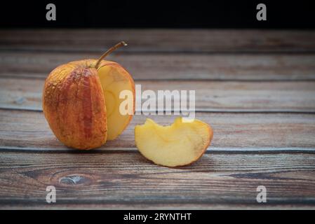 Mela marcillata rossa su un tavolo. Batteri infettano frutta marcio Foto Stock