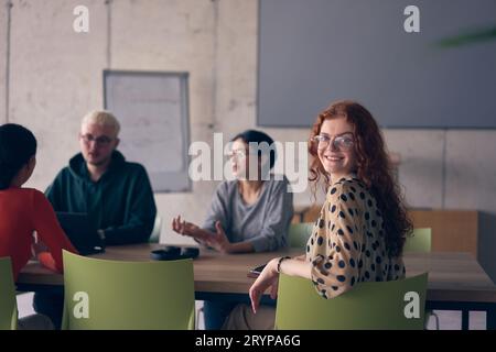 Un gruppo eterogeneo di professionisti si è riunito in un ufficio moderno per un incontro produttivo e inclusivo Foto Stock