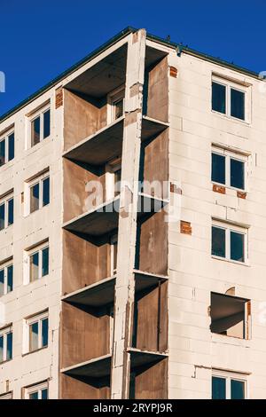 Edificio condominiale non finito con pannello isolante in espanso di polistirene rigido incollato alla parete esterna, vista angolare bassa Foto Stock
