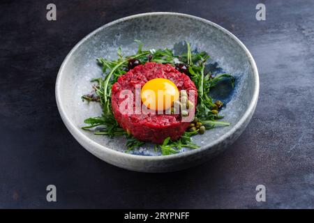 Tartaro gourmet di stile moderno crudo di filetto di manzo con uovo Foto Stock
