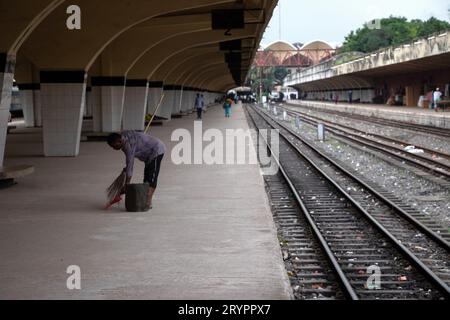 Dhaka, Dhaka, Bangladesh. 2 ottobre 2023. Un addetto alle pulizie spazza il pavimento alla stazione ferroviaria di Kamalapur a Dacca, Bangladesh. I loro instancabili sforzi spesso passano inosservati, eppure svolgono un ruolo vitale nel mantenere la pulizia e l'ordine della stazione. La stazione ferroviaria di Kamalapur è il più grande e vivace snodo ferroviario della nazione. Nota per la sua fusione architettonica di elementi moderni e tradizionali, questa stazione iconica è stata progettata dall'architetto americano Robert Boughey e inaugurata nel 1969. Gestendo quotidianamente un notevole volume di passeggeri e merci, Kamalapur svolge un ruolo fondamentale a Bangla Foto Stock