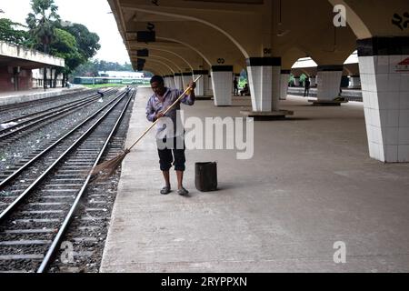 Dhaka, Dhaka, Bangladesh. 2 ottobre 2023. Un addetto alle pulizie spazza il pavimento alla stazione ferroviaria di Kamalapur a Dacca, Bangladesh. I loro instancabili sforzi spesso passano inosservati, eppure svolgono un ruolo vitale nel mantenere la pulizia e l'ordine della stazione. La stazione ferroviaria di Kamalapur è il più grande e vivace snodo ferroviario della nazione. Nota per la sua fusione architettonica di elementi moderni e tradizionali, questa stazione iconica è stata progettata dall'architetto americano Robert Boughey e inaugurata nel 1969. Gestendo quotidianamente un notevole volume di passeggeri e merci, Kamalapur svolge un ruolo fondamentale a Bangla Foto Stock