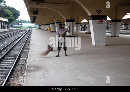 Dhaka, Dhaka, Bangladesh. 2 ottobre 2023. Un addetto alle pulizie spazza il pavimento alla stazione ferroviaria di Kamalapur a Dacca, Bangladesh. I loro instancabili sforzi spesso passano inosservati, eppure svolgono un ruolo vitale nel mantenere la pulizia e l'ordine della stazione. La stazione ferroviaria di Kamalapur è il più grande e vivace snodo ferroviario della nazione. Nota per la sua fusione architettonica di elementi moderni e tradizionali, questa stazione iconica è stata progettata dall'architetto americano Robert Boughey e inaugurata nel 1969. Gestendo quotidianamente un notevole volume di passeggeri e merci, Kamalapur svolge un ruolo fondamentale a Bangla Foto Stock