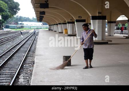 Dhaka, Dhaka, Bangladesh. 2 ottobre 2023. Un addetto alle pulizie spazza il pavimento alla stazione ferroviaria di Kamalapur a Dacca, Bangladesh. I loro instancabili sforzi spesso passano inosservati, eppure svolgono un ruolo vitale nel mantenere la pulizia e l'ordine della stazione. La stazione ferroviaria di Kamalapur è il più grande e vivace snodo ferroviario della nazione. Nota per la sua fusione architettonica di elementi moderni e tradizionali, questa stazione iconica è stata progettata dall'architetto americano Robert Boughey e inaugurata nel 1969. Gestendo quotidianamente un notevole volume di passeggeri e merci, Kamalapur svolge un ruolo fondamentale a Bangla Foto Stock