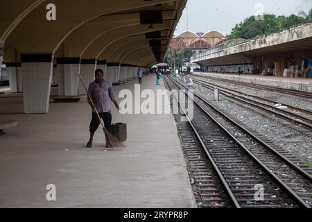 Dhaka, Dhaka, Bangladesh. 2 ottobre 2023. Un addetto alle pulizie spazza il pavimento alla stazione ferroviaria di Kamalapur a Dacca, Bangladesh. I loro instancabili sforzi spesso passano inosservati, eppure svolgono un ruolo vitale nel mantenere la pulizia e l'ordine della stazione. La stazione ferroviaria di Kamalapur è il più grande e vivace snodo ferroviario della nazione. Nota per la sua fusione architettonica di elementi moderni e tradizionali, questa stazione iconica è stata progettata dall'architetto americano Robert Boughey e inaugurata nel 1969. Gestendo quotidianamente un notevole volume di passeggeri e merci, Kamalapur svolge un ruolo fondamentale a Bangla Foto Stock
