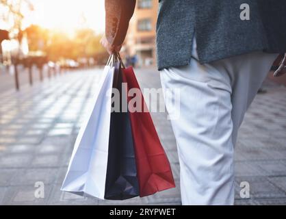 Concetto di uomo shopping e borse di contenimento, immagini closeup. Primo piano di borse di carta in mano maschile. Foto Stock