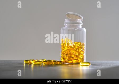 Un barattolo di capsule OMEGA 3 si trova su un tavolo scuro. Foto Stock