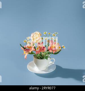 tazza bianca con fiori all'interno. Concetto Flowers Tea. Minimalismo Foto Stock