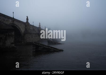 Vista mattutina da sogno del Ponte Carlo con magica atmosfera nebbiosa la mattina presto con il fiume Moldava nella città vecchia di Praga. Foto Stock