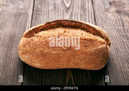 Pagnotta di pane multigrain di segale fresco su fondo di tavola di legno. Panetteria, concetto di cibo Foto Stock
