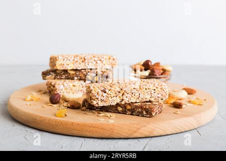 Vari barrette di muesli su sfondo tavolo. Barrette di cereali. Bar per la colazione superfood con avena, noci e frutti di bosco, primo piano. Concetto superfood. Foto Stock