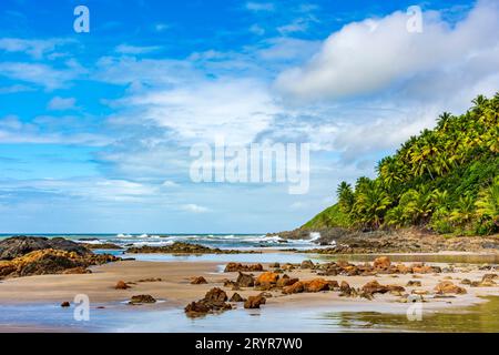 Spiaggia rocciosa deserta chiamata Prainha circondata da alberi di cocco e vegetazione Foto Stock