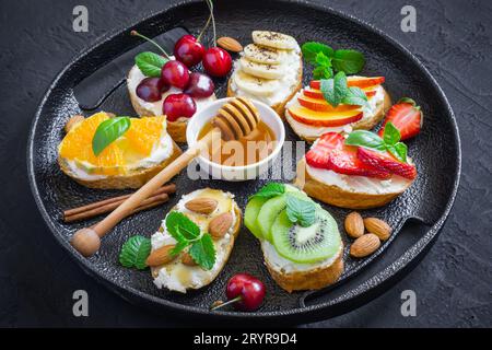 Spuntini dolci estivi assortiti. Bruschetta o sandwich con frui Foto Stock
