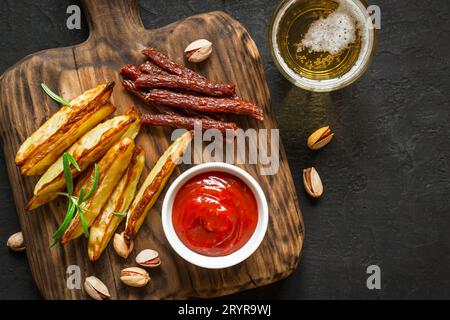 Spuntini vari per la birra. Patate fritte peperoni noci e un bicchiere di birra Foto Stock