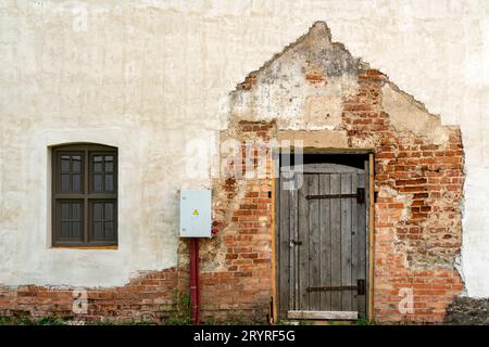 Quadro di comando elettrico sulla vecchia parete di mattoni incrinati Foto Stock