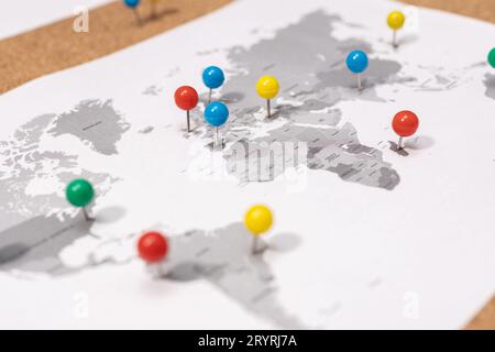 Primo piano di Pushpin sulla mappa del mondo su Corkboard. Concetto di destinazione di viaggio Foto Stock