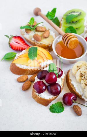 Selezione di spuntini dolci estivi. Bruschetta o sandwich con fru Foto Stock