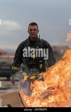 Primo piano ritratto di un eroico pompiere in tuta protettiva. Vigile del fuoco durante l'operazione antincendio. Foto Stock