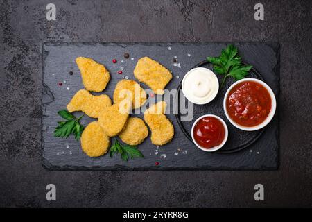 Pepite di pollo croccanti fritte con salse popolari Foto Stock