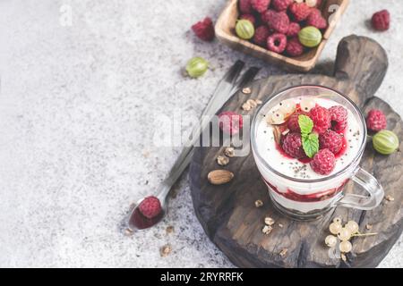 Bicchiere con lamponi, muesli e yogurt disposti a strati Foto Stock