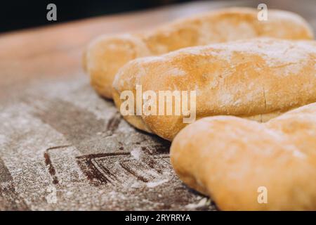 Un primo piano di tre panini di pane artigianale appena sfornati su un tovagliolo Foto Stock