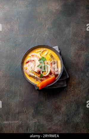 Peruviano zuppa di pesce Chupe de camarones in grigio ciotola, vista dall'alto Foto Stock